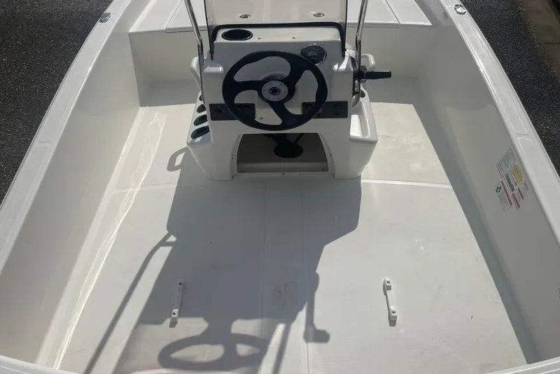 Slide: The Image of 2026 Mako Pro Skiff 15 CC boat interior with steering console and seating area. - 2