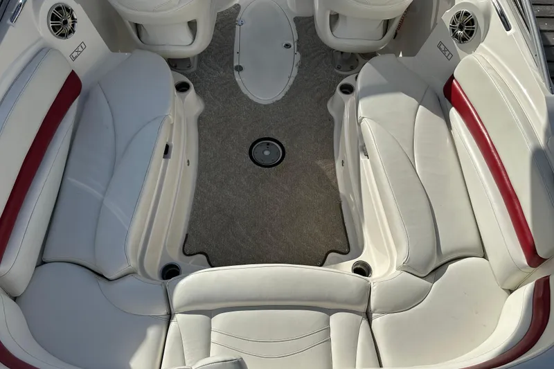 Slide: The Image of 2008 Larson LXi 288 boat interior with white and red seating, carpeted floor, and cup holders. - 10