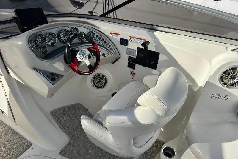 Slide: The Image of 2008 Larson LXi 288 boat cockpit with steering wheel, gauges, and white seating. - 15