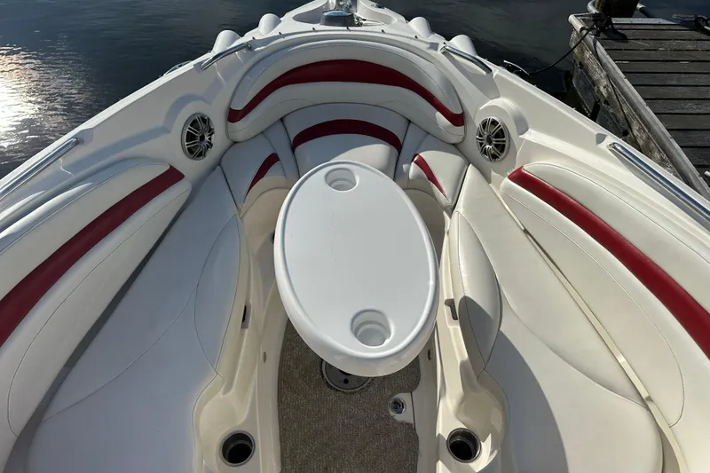 Slide: The Image of 2008 Larson LXi 288 boat interior with white and red seating, round table, and speakers. - 18