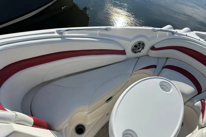 Slide: The Image of 2008 Larson LXi 288 boat interior with white and red seating, round table, and speaker. - 19