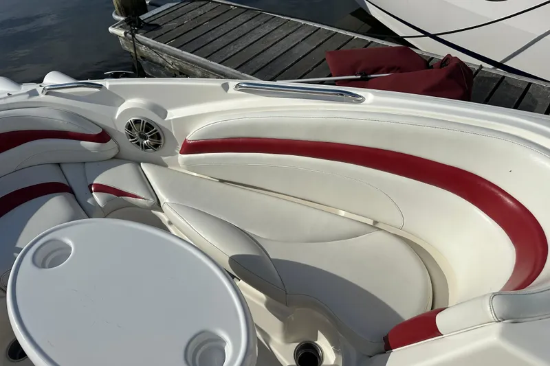 Slide: The Image of 2008 Larson LXi 288 boat interior with red and white seating near dock. - 20