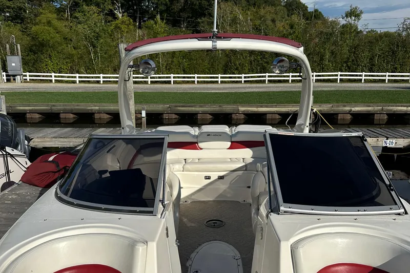 Slide: The Image of 2008 Larson LXi 288 boat docked, featuring red and white interior with open cockpit. - 28