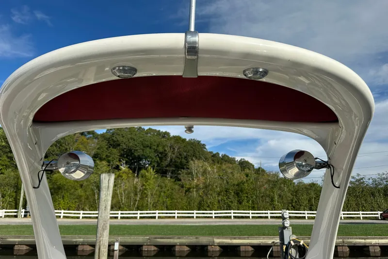 Slide: The Image of 2008 Larson LXi 288 boat canopy with lights, docked near lush greenery. - 29