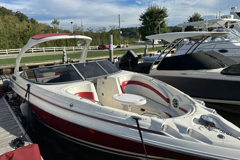 Slide: The Image of 2008 Larson LXi 288 boat docked, featuring red and white design with spacious seating. - 3