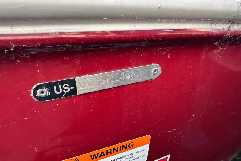 Slide: The Image of 2008 Larson LXi 288 boat hull identification number on red surface. - 34