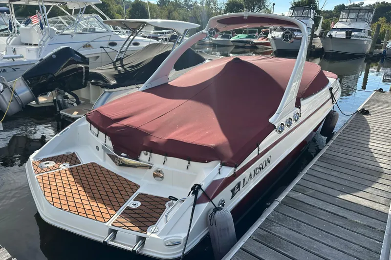 Slide: The Image of 2008 Larson LXi 288 boat docked with maroon cover and wooden deck. - 6