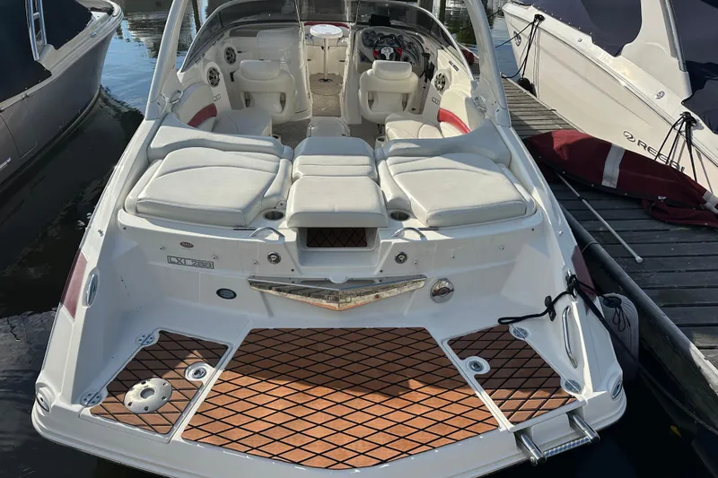 Slide: The Image of 2008 Larson LXi 288 boat with white seating and wood-patterned deck, docked at marina. - 8