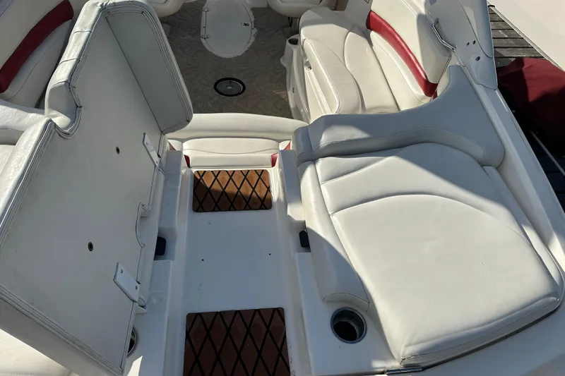 Slide: The Image of 2008 Larson LXi 288 boat interior with white and red seating, cup holders, and storage compartments. - 9