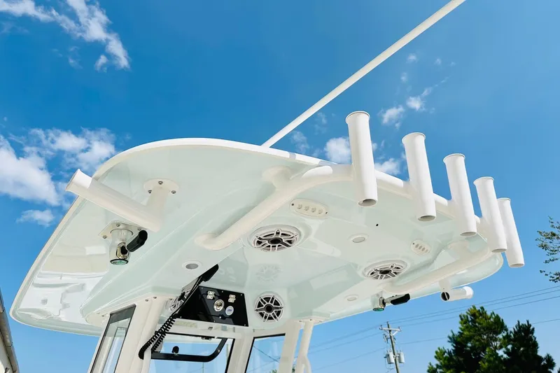 Slide: The Image of 2025 Sportsman Heritage 261 Center Console boat top view with rod holders against blue sky. - 7