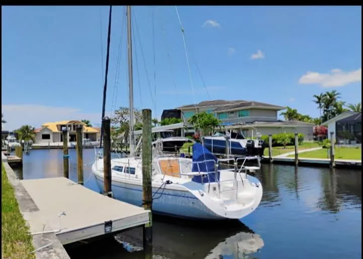 Slide: The Image of 2002 Catalina 34 Mark II sailboat docked in a sunny residential canal. - 2