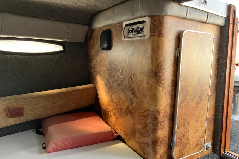 Slide: The Image of Interior cabin of 1983 Chris-Craft 230 Scorpion boat with wood paneling and cushion. - 14
