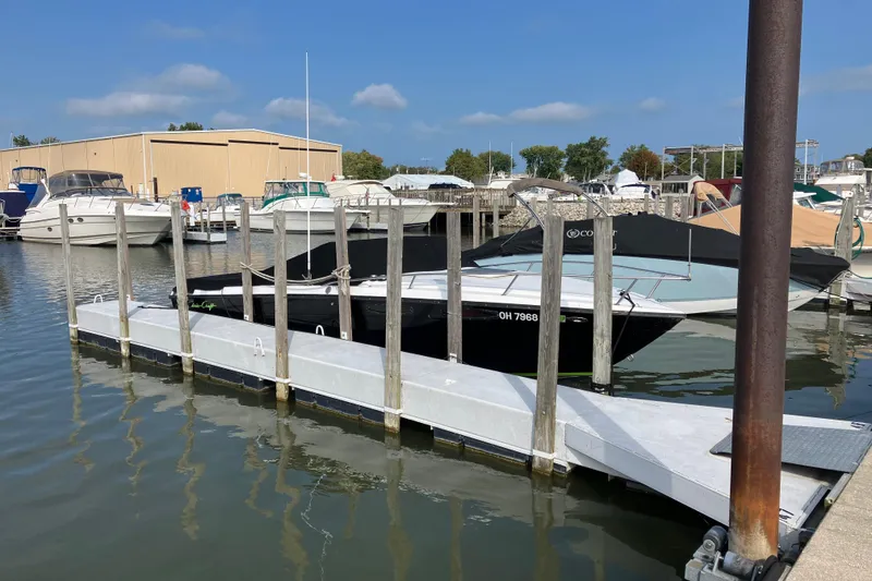 Slide: The Image of 1983 Chris-Craft 230 Scorpion docked at a marina under clear skies. - 1