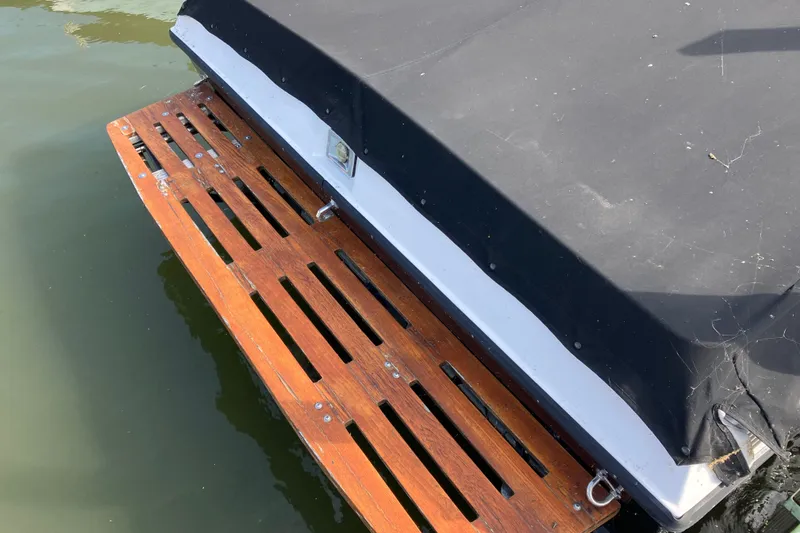 Slide: The Image of 1983 Chris-Craft 230 Scorpion boat with wooden swim platform and black cover. - 3