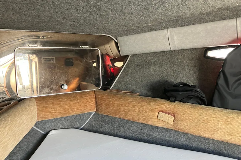 Slide: The Image of Interior cabin of 1983 Chris-Craft 230 Scorpion boat, featuring cushioned seating and storage. - 16