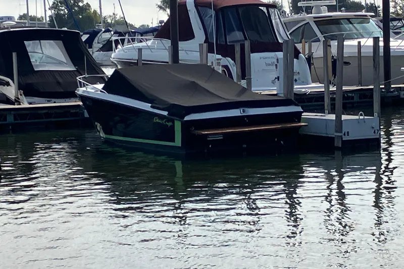 Slide: The Image of 1983 Chris-Craft 230 Scorpion boat docked with cover, surrounded by other boats. - 2