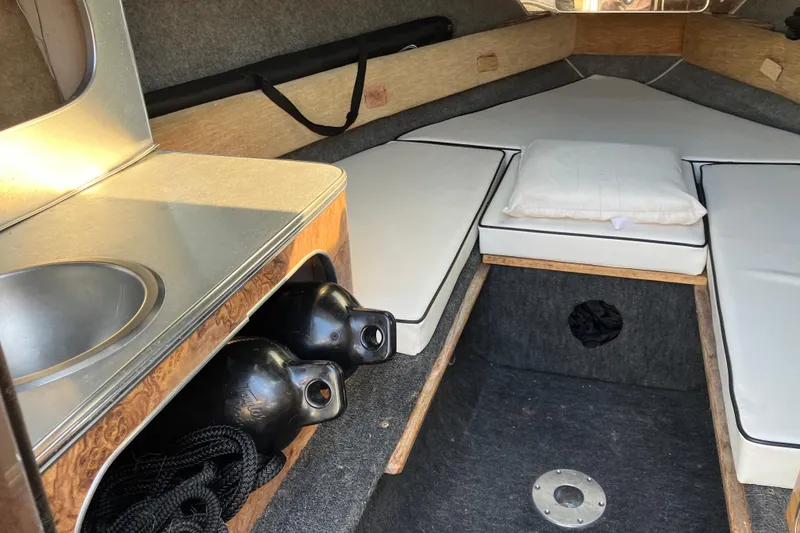 Slide: The Image of Interior of 1983 Chris-Craft 230 Scorpion boat with sink and cushioned seating. - 13