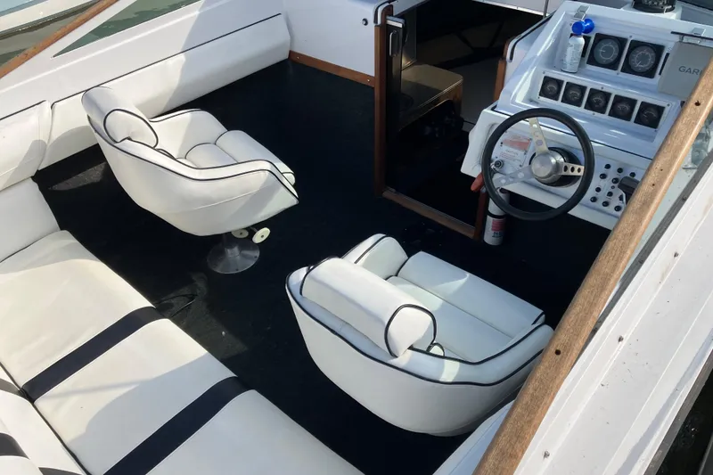 Slide: The Image of 1983 Chris-Craft 230 Scorpion boat interior with white seating and steering console. - 4