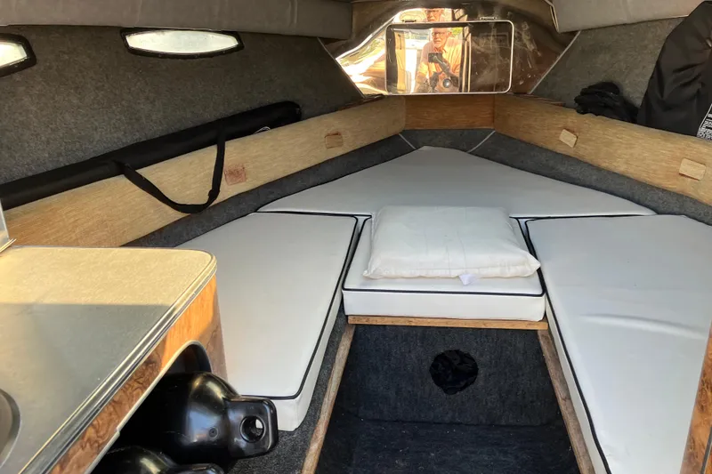 Slide: The Image of Interior cabin of 1983 Chris-Craft 230 Scorpion boat with white cushions and wood accents. - 12