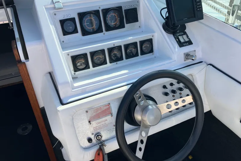 Slide: The Image of 1983 Chris-Craft 230 Scorpion boat dashboard with steering wheel and instrument panel. - 6