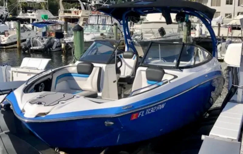 Slide: The Image of 2019 Yamaha Boats 242X E-Series in marina, blue and white design, luxury seating. - 5