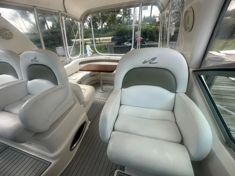 Slide: The Image of 2006 Sea Ray 340 Sundancer interior with white leather seating and a wooden table. - 33