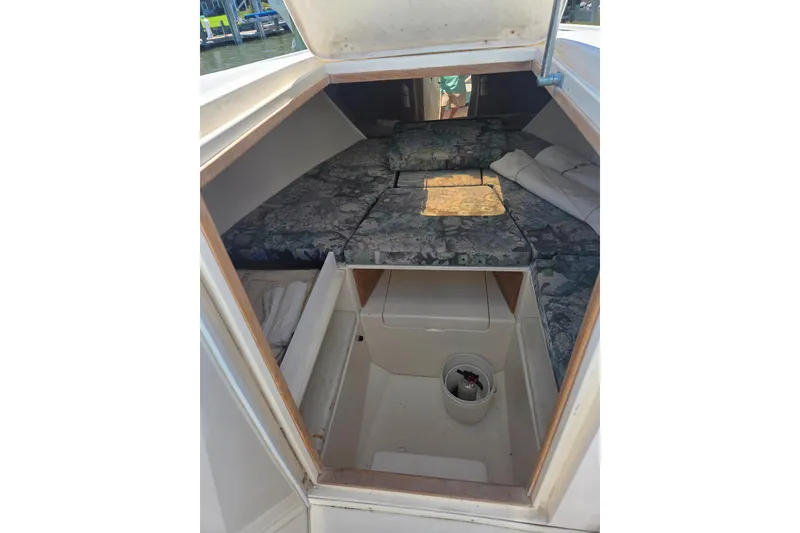 Slide: The Image of 1997 Intrepid 322 boat cabin interior with patterned cushions and storage space. - 12