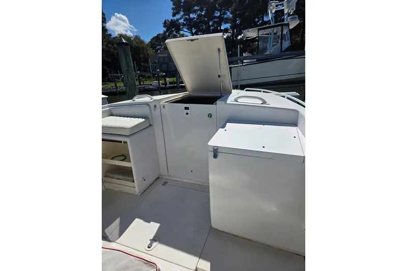 Slide: The Image of 1997 Intrepid 322 boat interior with open storage compartments and seating. - 13