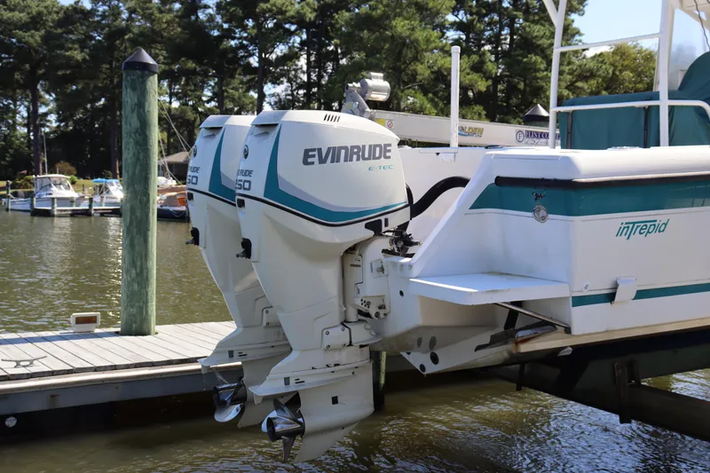 Slide: The Image of 1997 Intrepid 322 boat with dual Evinrude engines docked by a marina. - 6