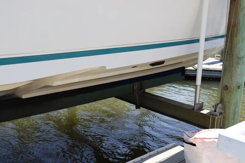 Slide: The Image of 1997 Intrepid 322 boat hull on lift, docked over water. - 8