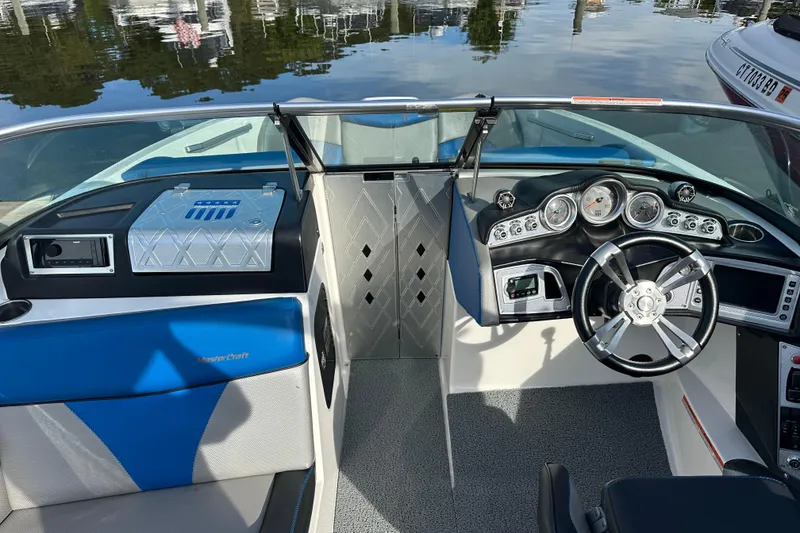 Slide: The Image of 2016 MasterCraft X23 boat interior with steering wheel and dashboard controls. - 10