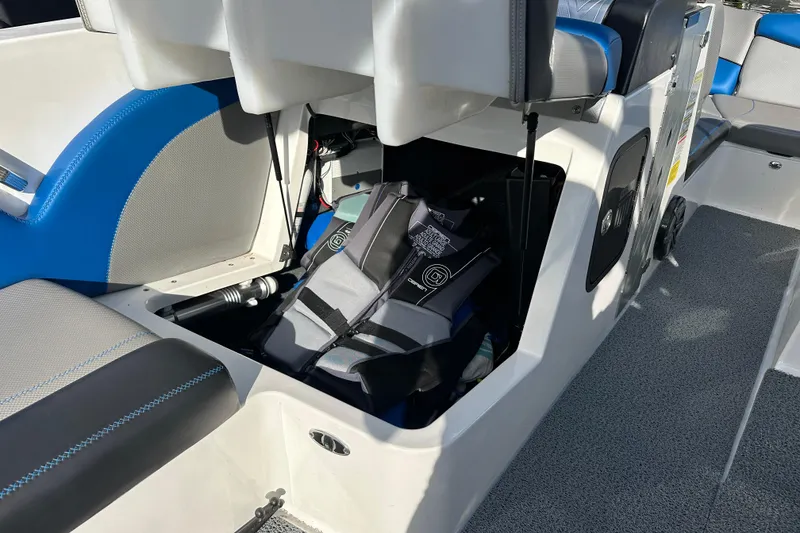 Slide: The Image of 2016 MasterCraft X23 boat interior with open storage compartment and life jacket. - 12