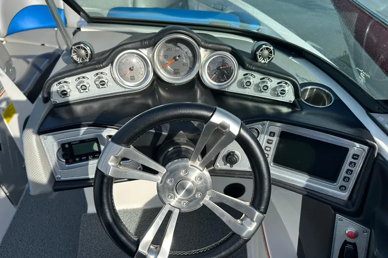 Slide: The Image of 2016 MasterCraft X23 boat dashboard with steering wheel and control gauges. - 14