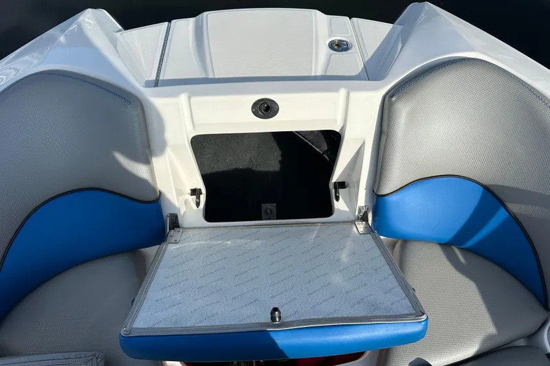 Slide: The Image of 2016 MasterCraft X23 boat interior with blue and gray seating and storage compartment. - 20