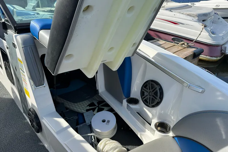 Slide: The Image of 2016 MasterCraft X23 boat interior storage compartment with speaker and cup holders. - 22