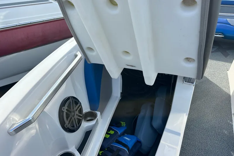 Slide: The Image of 2016 MasterCraft X23 boat storage compartment with speaker and grab handle. - 23