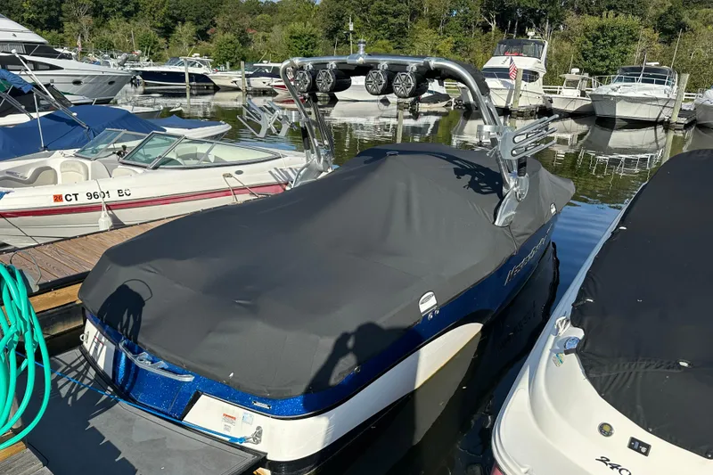 Slide: The Image of 2016 MasterCraft X23 boat covered at marina, surrounded by other boats. - 26