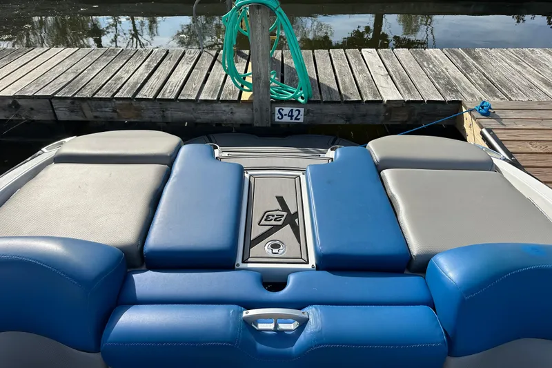 Slide: The Image of 2016 MasterCraft X23 boat with blue and gray seating at a dock. - 4