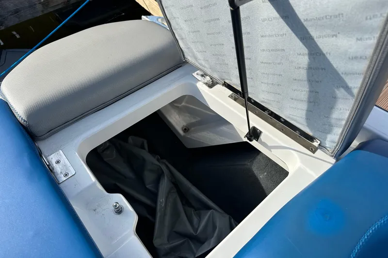 Slide: The Image of Open storage compartment in 2016 MasterCraft X23 boat, showing interior details and upholstery. - 5