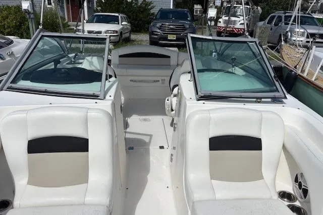 Slide: The Image of 2011 Chaparral 224 Sunesta boat interior with white seating and dual windshields. - 10