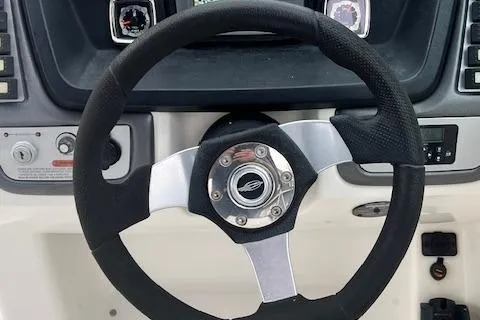 Slide: The Image of Steering wheel of a 2011 Chaparral 224 Sunesta boat, featuring a modern dashboard design. - 6