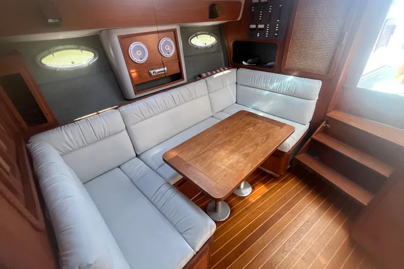 Slide: The Image of 1987 Tiara Yachts 3100 Open interior with white seating and wooden table. - 10