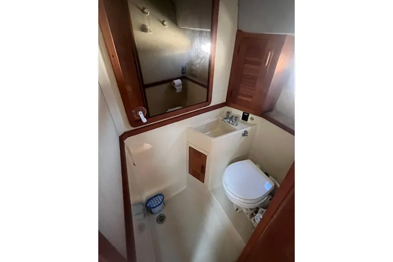Slide: The Image of 1987 Tiara Yachts 3100 Open bathroom with sink, toilet, and mirror. - 12