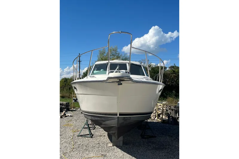 Slide: The Image of 1987 Tiara Yachts 3100 Open boat on land under a clear blue sky. - 3