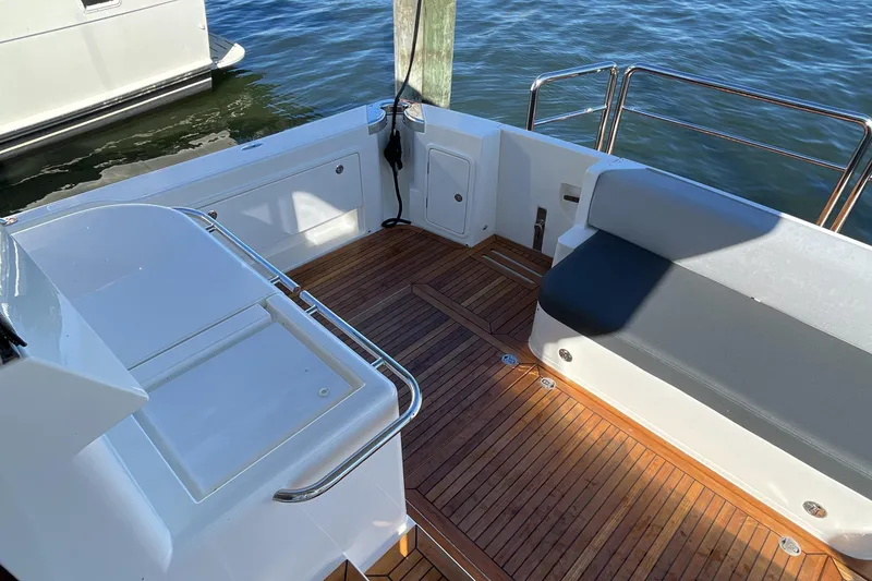 Slide: The Image of 2025 Riviera 585 SUV yacht deck with wooden flooring and seating area. - 11