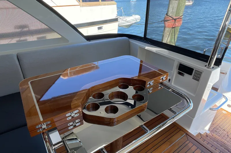 Slide: The Image of Luxurious interior of 2025 Riviera 585 SUV yacht with polished wood table and cup holders. - 18