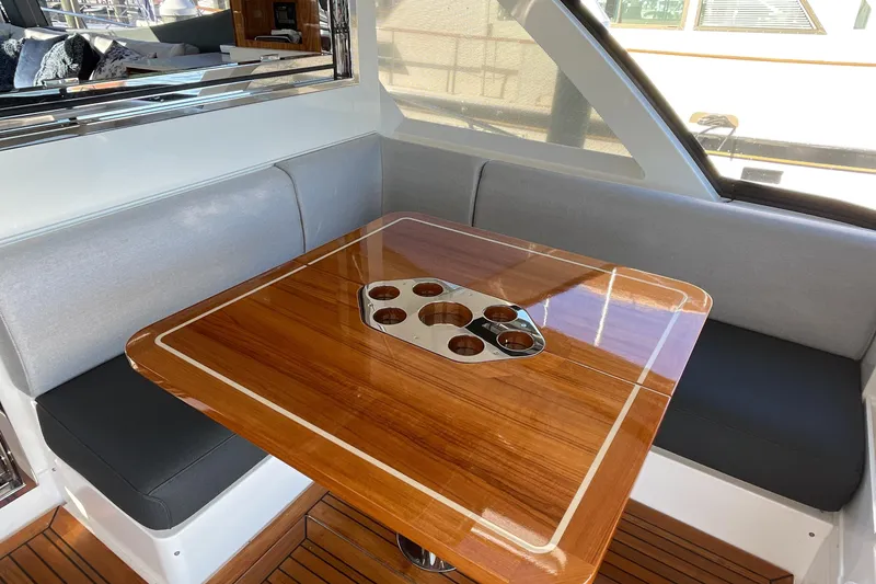 Slide: The Image of Luxurious interior of 2025 Riviera 585 SUV with polished wooden table and cushioned seating. - 19