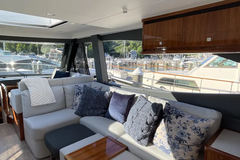Slide: The Image of Luxurious interior of 2025 Riviera 585 SUV yacht with plush seating and scenic marina view. - 26