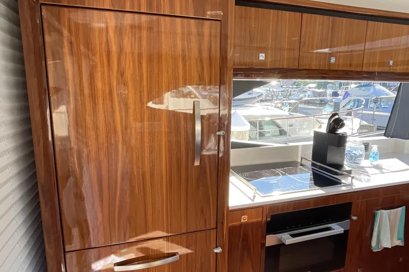 Slide: The Image of Luxurious kitchen interior of 2025 Riviera 585 SUV yacht with wood finish and modern appliances. - 34