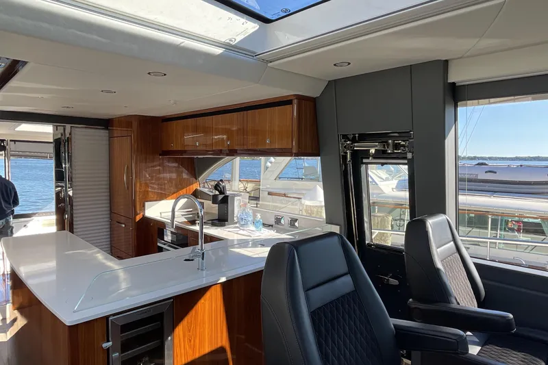 Slide: The Image of Luxurious interior of 2025 Riviera 585 SUV yacht with modern kitchen and seating. - 36